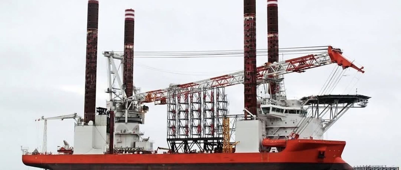 Jack-up fartøj med fire ben og stor kran ved kaj i Esbjerg havn