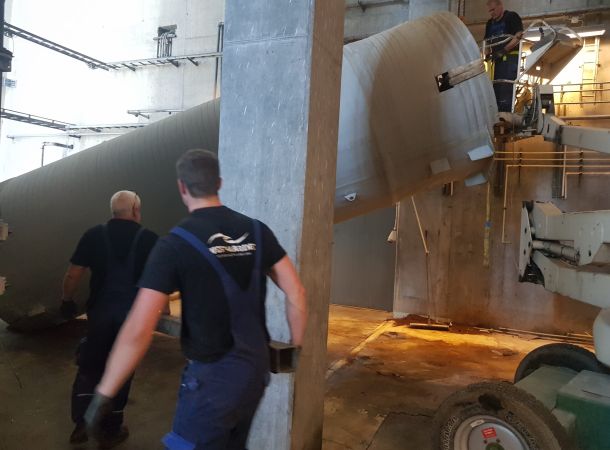 West-Marine-teknikere flytter en stor industribeholder med kran hos Energnist